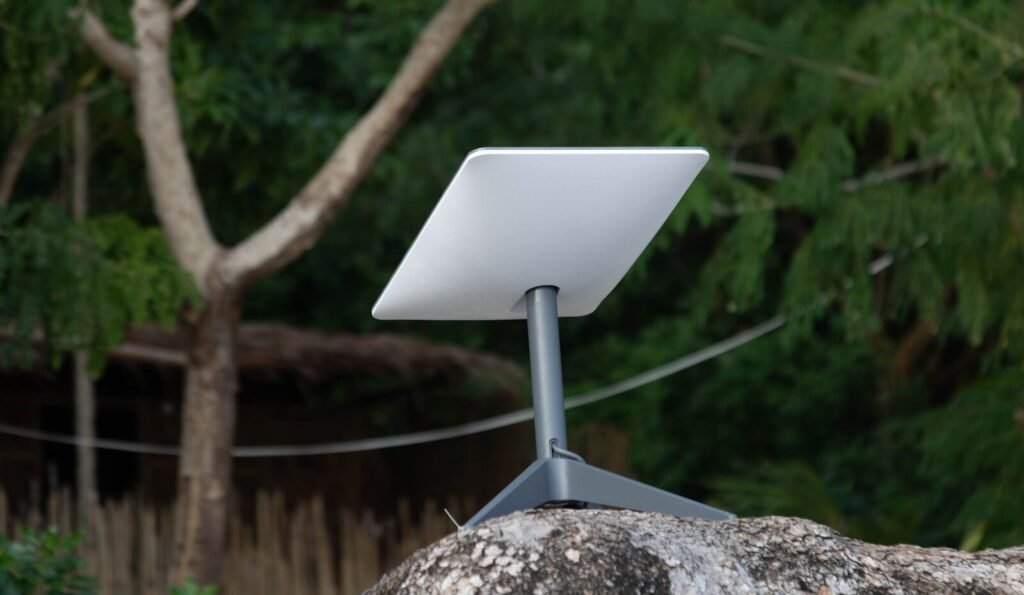White satellite dish on a stand on rocks